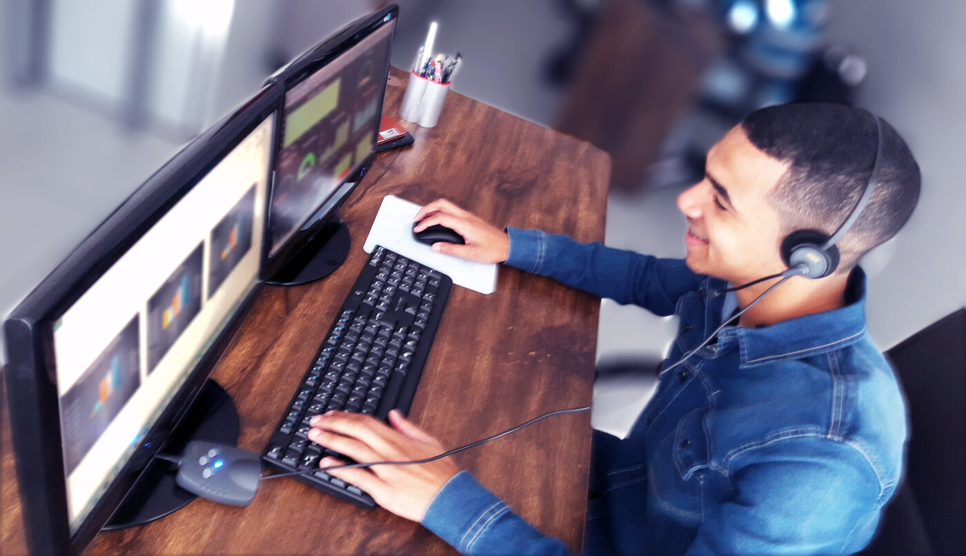 Atendente da IpChronus fazendo uma ligação com headset, em frente a monitores